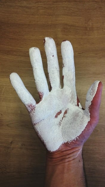 A close-up photo showing a person's hands with visible signs of physical abuse (bruises, scars) in a sterile, unwelcoming environment, such as a factory or agricultural setting.
