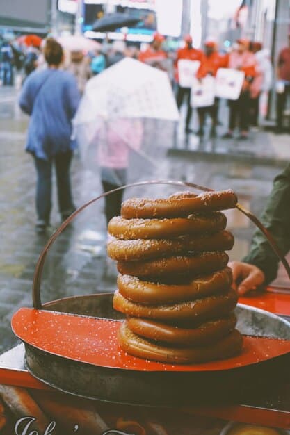 A vibrant food stall at a New Orleans food festival, featuring beignets being freshly fried and coated in powdered sugar. People are lined up eagerly to purchase them.
