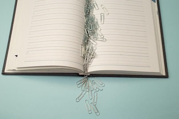 A close-up of a phrasebook open to a page displaying common greetings and polite phrases in Spanish, with a pen underlining the phrase 