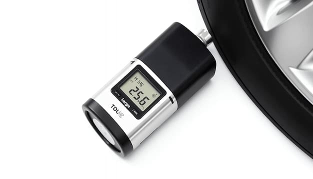 A close-up of a digital tire pressure gauge showing a reading of 35 PSI, displayed against the backdrop of a car tire valve. The image is clean with a clear display focus.