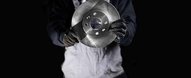 A close-up shot of a mechanic inspecting brake rotors and pads. The focus is on the detail of the brake components, with clear visibility of the rotor surface, brake pad thickness, and caliper assembly. The surrounding area is slightly blurred, emphasizing the brake system's importance.