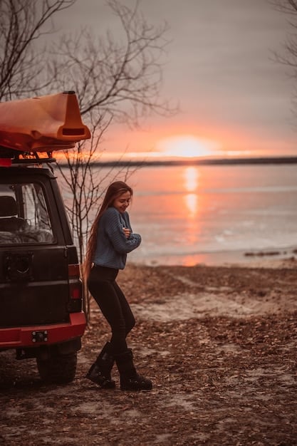 A serene beach at sunset, with an RV parked nearby. The scene portrays relaxation and freedom, capturing the essence of a laid-back road trip lifestyle.