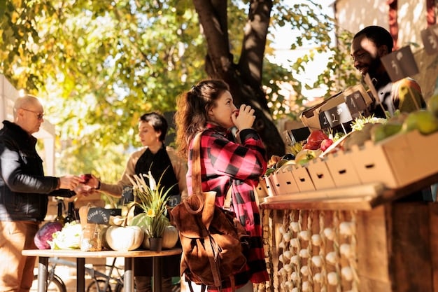 A bustling farmers market in a small US town, featuring local vendors selling fresh produce, artisanal crafts, and regional delicacies, with tourists interacting with the locals and sampling various products.