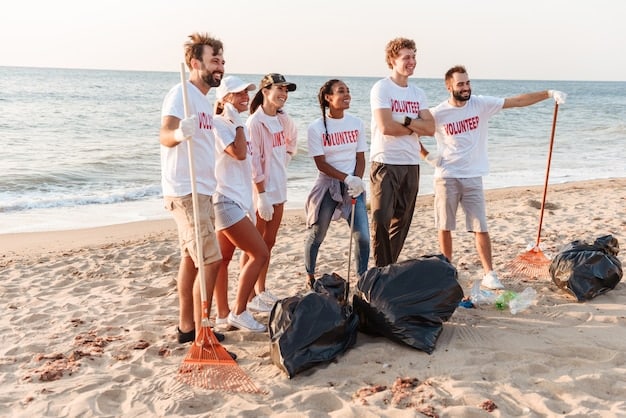 Travelers participating in a beach cleanup activity on a US coastal town. They are wearing gloves and collecting trash, with the ocean and a blue sky in the background, promoting environmental awareness and sustainable tourism.