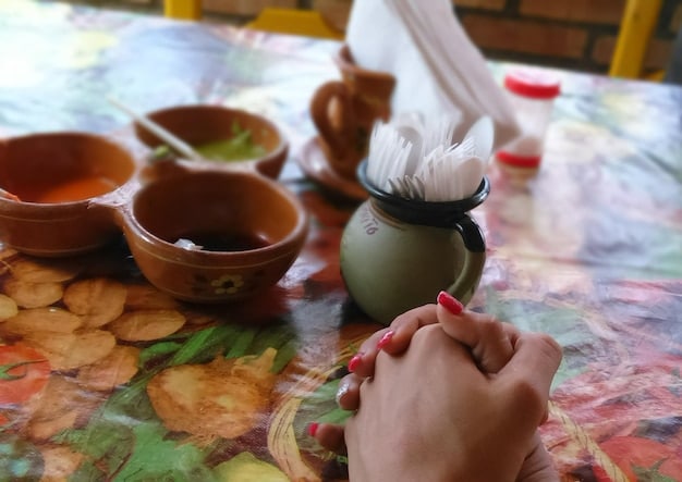 A close-up shot of an Indigenous artisan crafting traditional pottery, showcasing the intricate details and cultural significance of the artwork. The artisan is smiling and directly engaging with the viewer. Focus on preserving cultural heritage through supporting Indigenous art.