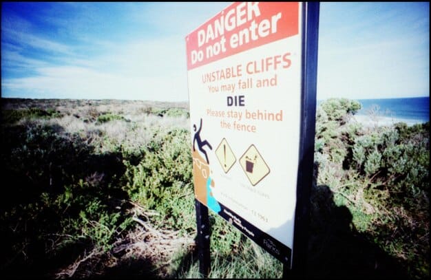 A close-up of a sign posted at the entrance of a US National Park clearly stating the rules and regulations regarding wildlife interaction and photography, emphasizing the importance of maintaining a safe distance and respecting the natural habitat.