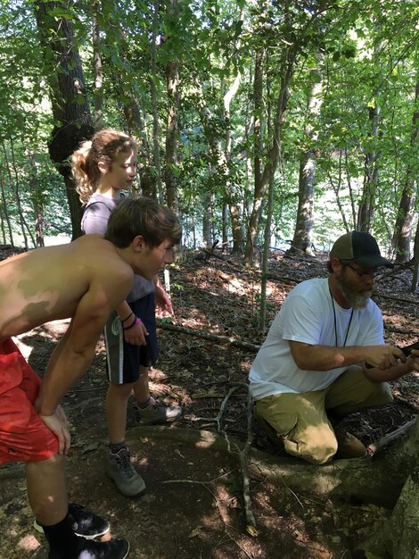 A group of volunteers planting trees in a deforested area, with visible signs of reforestation efforts. The image highlights the importance of conservation partnerships.