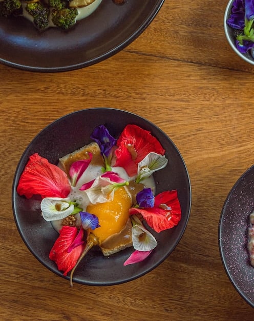 A close-up of a dish served in a sustainable restaurant, showcasing locally sourced ingredients arranged creatively. The image highlights the freshness and quality of the food, with visible details of the textures and colors.