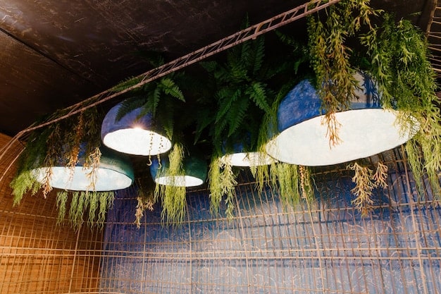 Interior of a sustainable restaurant, showing the decor with recycled or upcycled materials, energy-efficient lighting, and a focus on natural elements. The image portrays a cozy and eco-friendly ambiance.