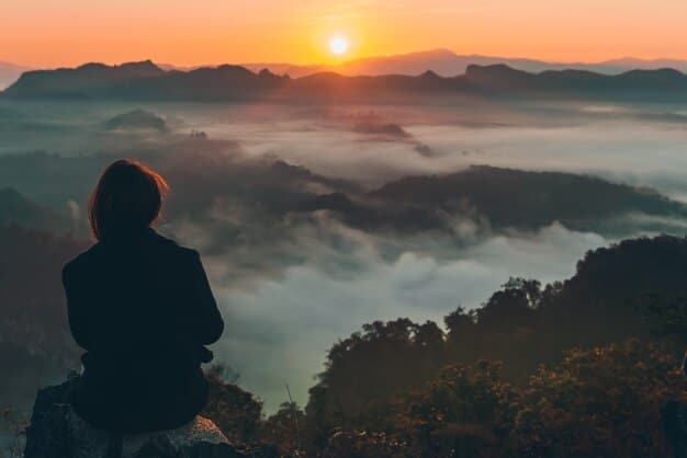 A traveler sitting on a hilltop, silhouetted against a vibrant sunset, looking out at a vast landscape. The image evokes a sense of solitude, reflection, and the transformative power of travel.