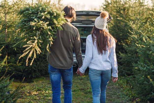 A family is seen standing next to their campervan, parked at a scenic overlook in a national park. The van is equipped with solar panels, and camping gear is neatly stored inside. The family is smiling and appears to be enjoying the view and the freedom of their road trip.