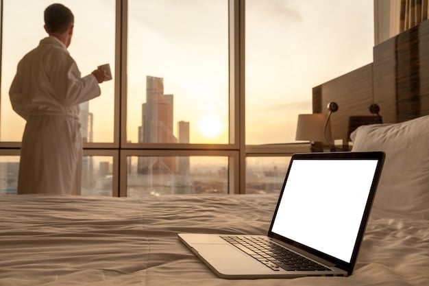 An image of a modern hotel room setup with both a professional workspace (desk, laptop, video conferencing equipment) and a comfortable leisure area (cozy seating, view of a scenic landscape), perfectly illustrating the blend of business and leisure travel.