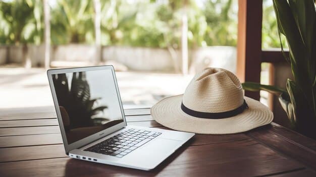 A close-up shot of a laptop on a hotel desk next to a sun hat and sunglasses, with a beach visible through the window in the background. This image represents the duality of bleisure travel, balancing work responsibilities with the opportunity for relaxation and leisure.