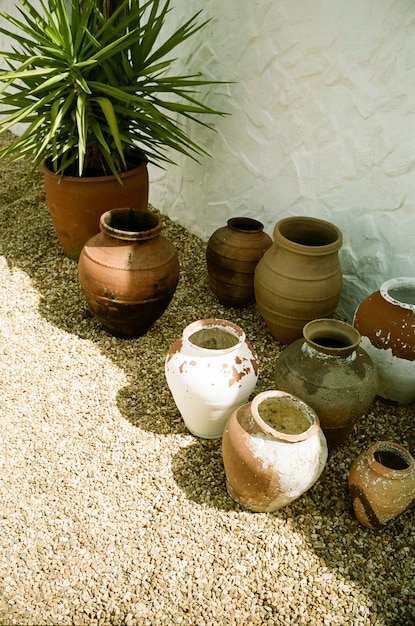 A display of handcrafted pottery made from locally sourced clay, showcasing natural colors and textures. The pottery is displayed in an outdoor setting, emphasizing its connection to the environment.
